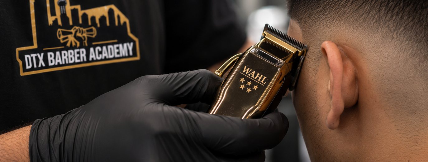 A gold clipper cutting the fade line on a real client at DTX