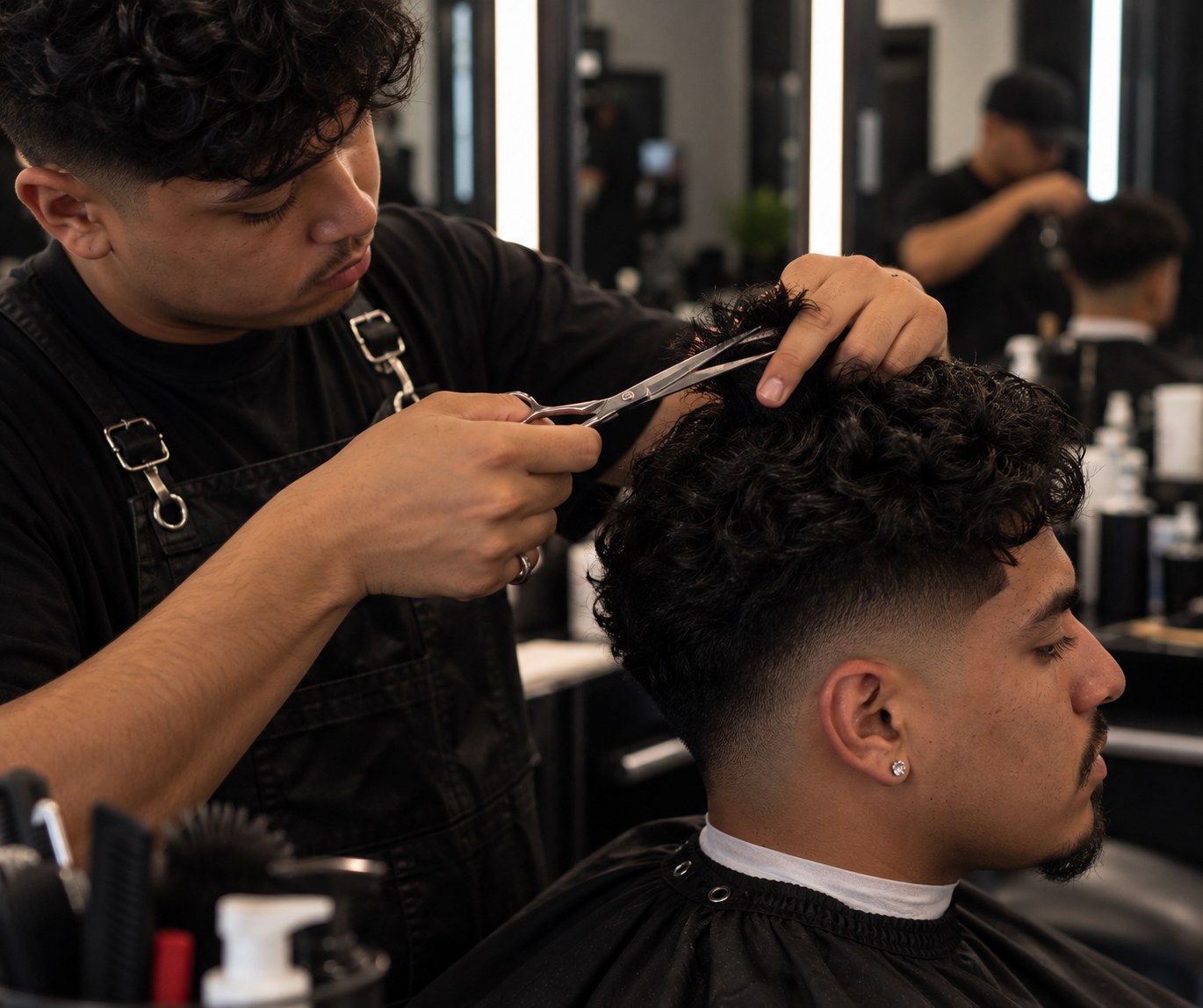 A student cutting curly hair with shears at the chair